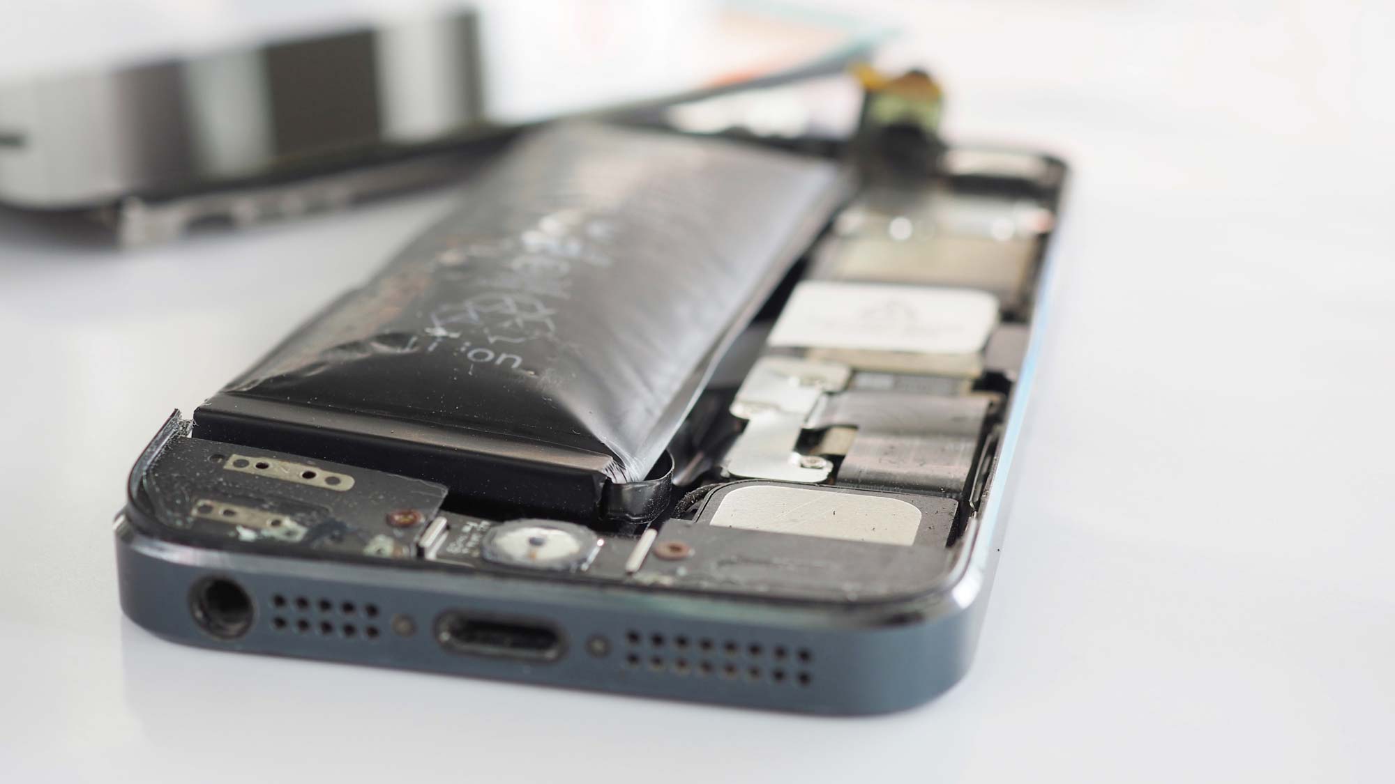  A swollen or damaged lithium-ion battery inside the back casing of a smartphone.