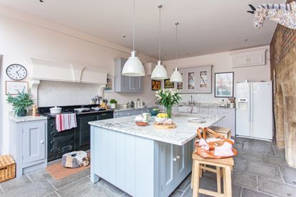 interior of kitchen in grade i listed tudor home with grey cabinets and aga