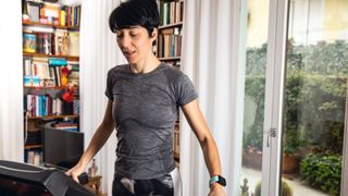 Woman walking on treadmill at home