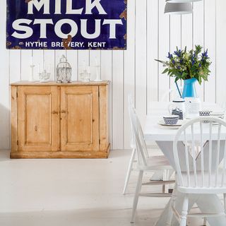 dining area with white wall and white dinner table and chair and wooden cabinet