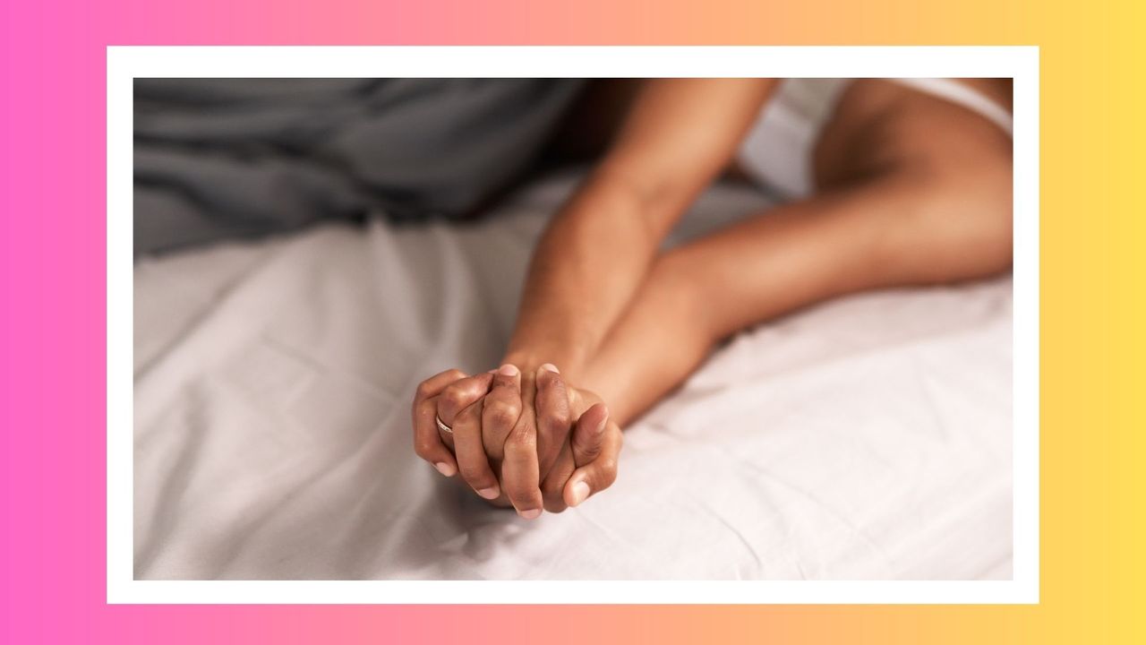 couple holding hands in bed to illustrate lesbian sex positions, with pink and yellow border around image