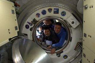 Soyuz TMA-17M crewmembers Oleg Kononenko, Kjell Lindgren and Kimiya Yui peer out of Soyuz TMA-17M before closing the hatch to return home to Earth.