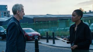 Peter Capaldi and Cush Jumbo having a conversation next to a road in Criminal Record