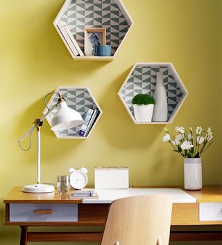 Modern home office ideas with yellow wall and hexagonal wall shelves