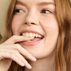 image of a model from LoveShackFancy fashion show biting her finger