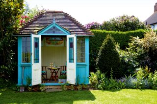 summer house ideas: deep blue building with stained glass windows on lawn