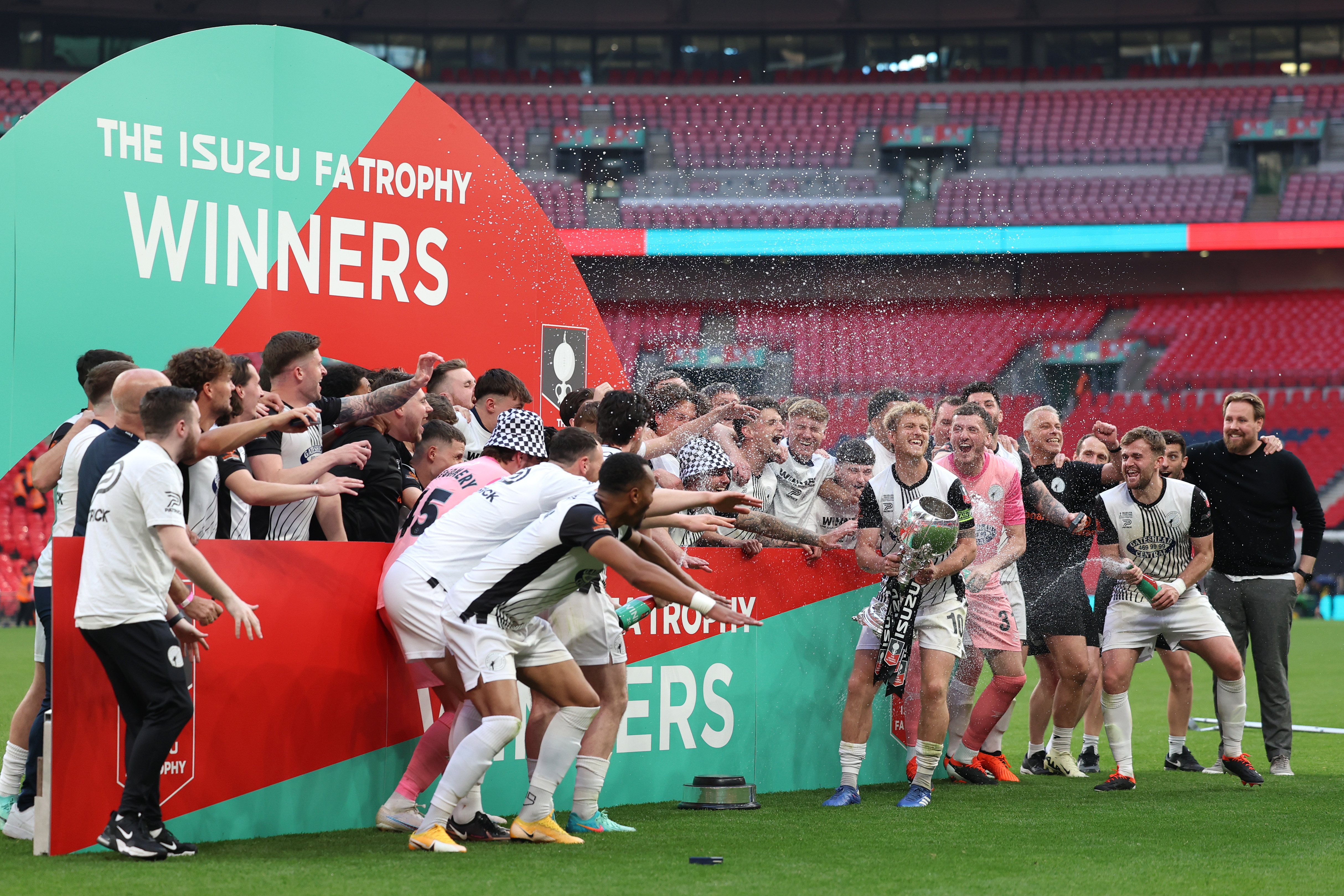 LONDON, ENGLAND - MAY 11: Greg Olley of Gateshead FC lifts the Isuzu FA Trophy with team mates and Rob Elliot, Manager of Gateshead FC, following the Isuzu FA Trophy Final between Gateshead FC and Solihull Moors FC at Wembley Stadium on May 11, 2024 in London, England. (Photo by Tom Dulat - The FA/The FA via Getty Images)