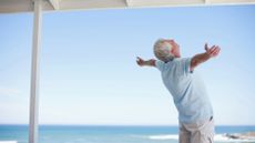 Senior man standing with arms outstretched 