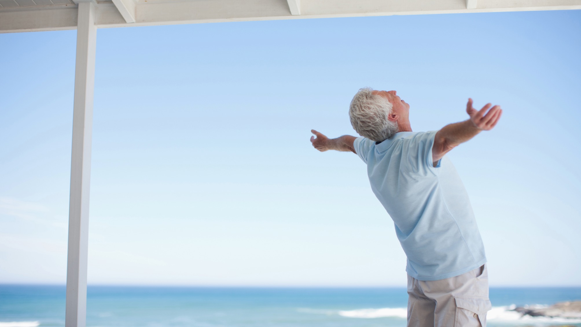 Senior man standing with arms outstretched 