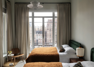 A bedroom in gray, with dark yellow or ochre bedding