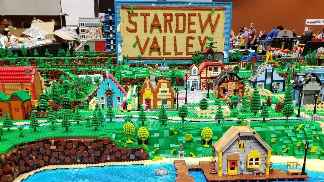 A photo of a Lego build on a table at a convention which replicates Pelican Town from Stardew Valley