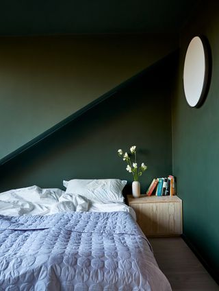 an attic bedroom painted dark green