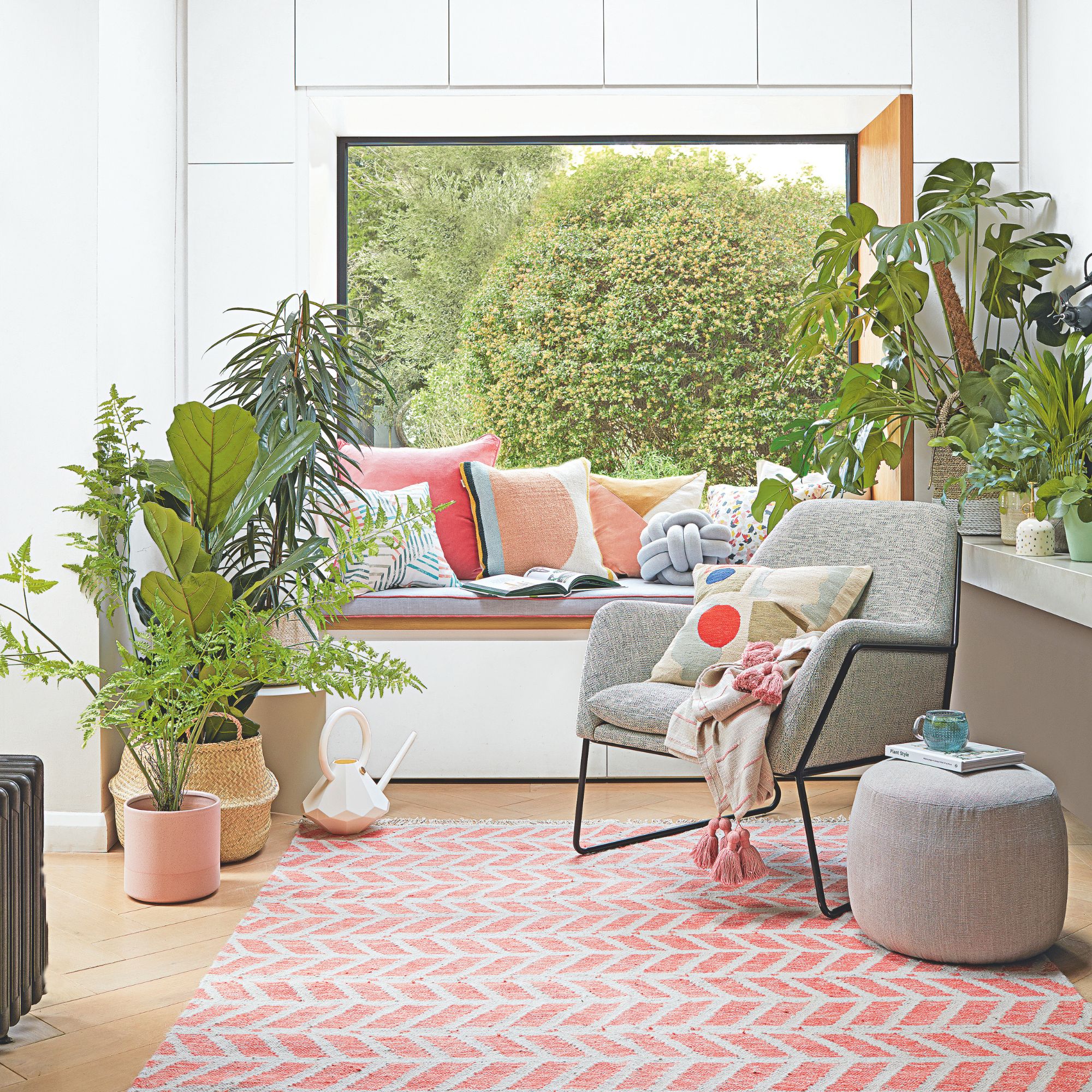 Living space with a bay window seat and an accent chair surrounded by houseplants