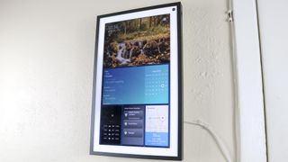 An Echo Show 15 smart display in portrait mode mounted to a kitchen wall