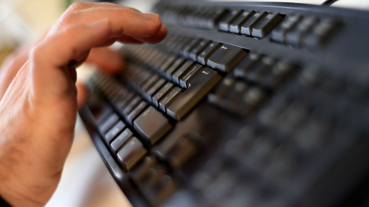 A hand typing on a keyboard