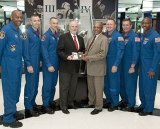 The STS-129 astronaut crew presents the space-flown flip coin to NFL officials at the Pro Football Hall of Fame on Jan. 27, 2010. The coin will decide the start of Super Bowl 44 in South Florida.