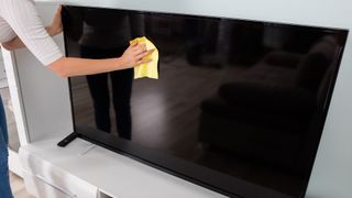 cleaning a TV screen with cloth