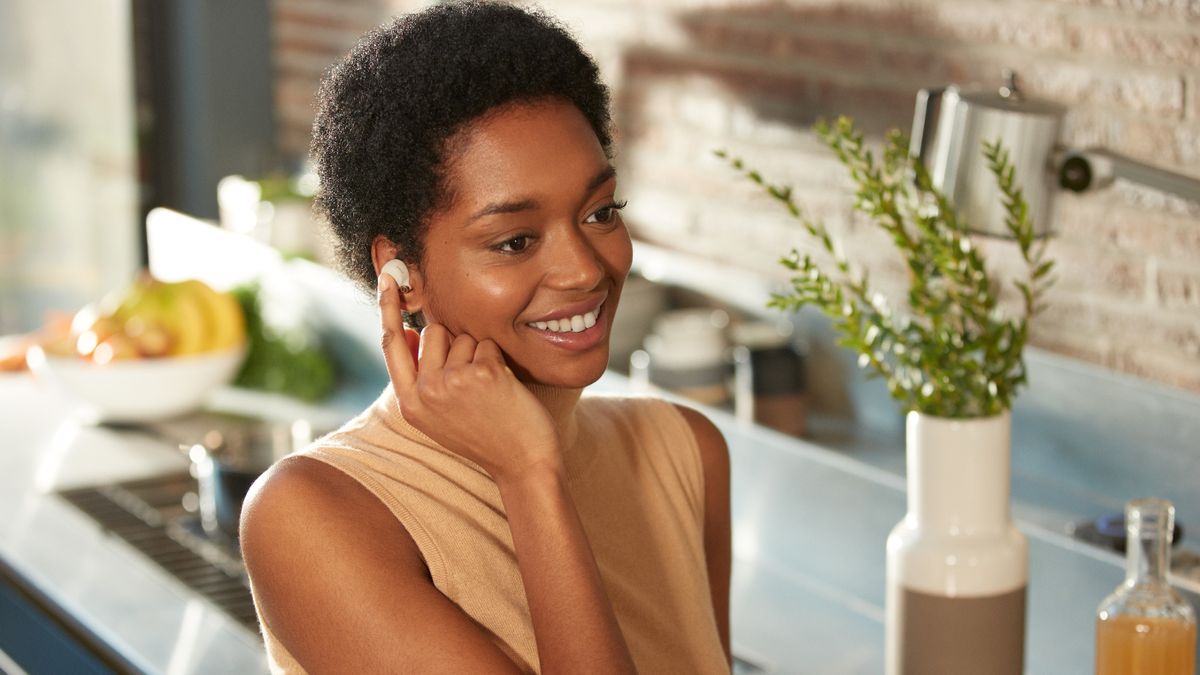  a woman wearing the Sony WF-1000XM4 wireless earbuds