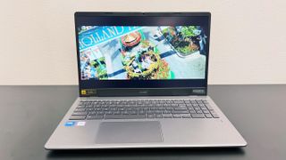 The Acer Chromebook Plus Enterprise 515 playing a movie trailer, on a black desk against a white background.