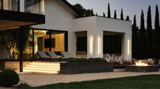 An outdoor area, with a lush garden and steps illuminated with recessed lights