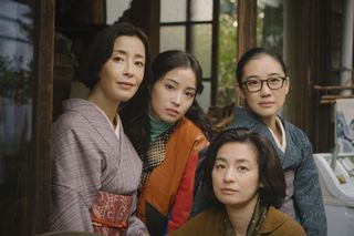 The cast of Netflix's Japanese show 'Asura' wearing traditional japanese kimonos and posing together in the doorway of a home