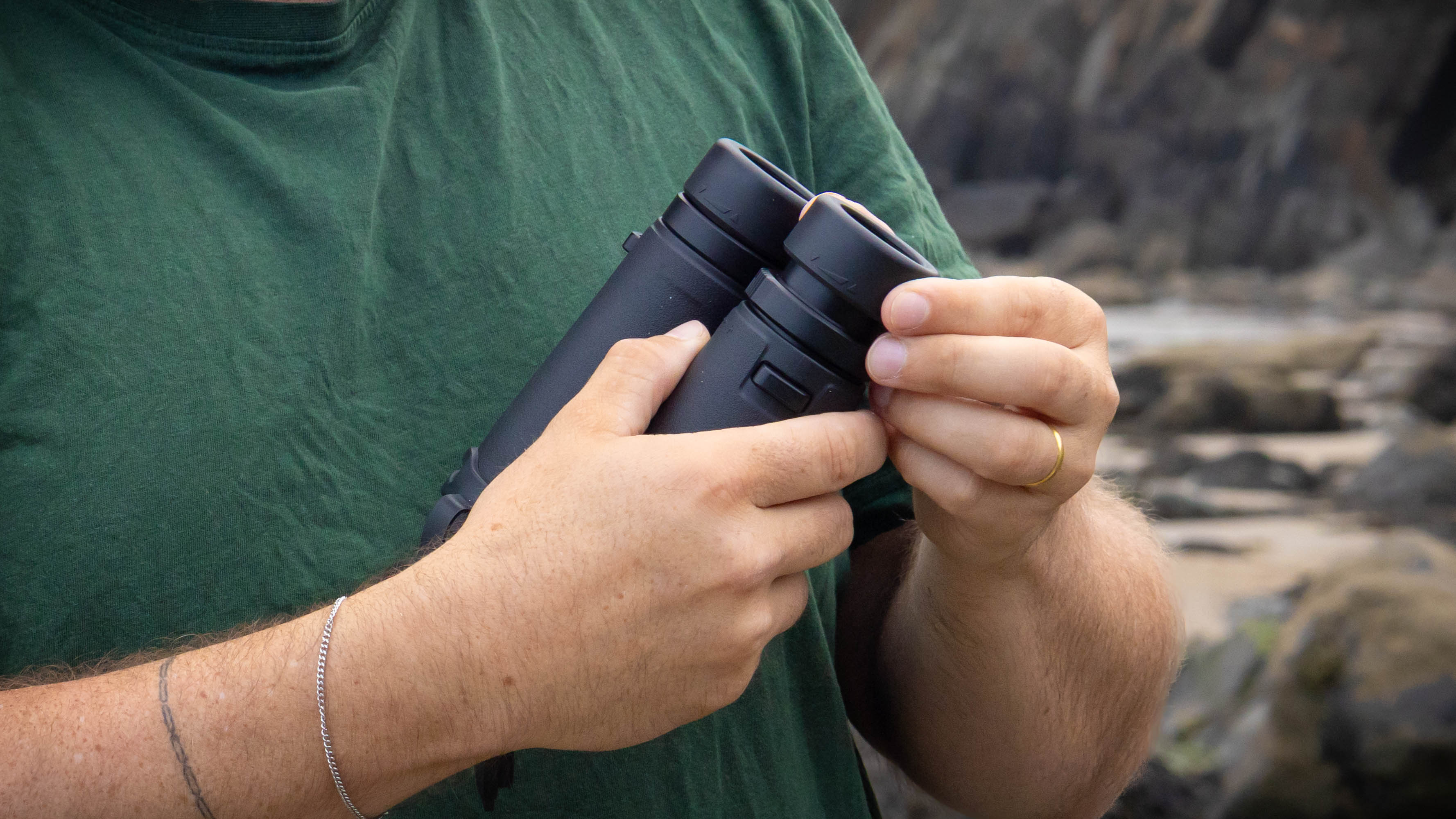 A close-up of a person holding the Nikon Monarch M7 8x42 binoculars.