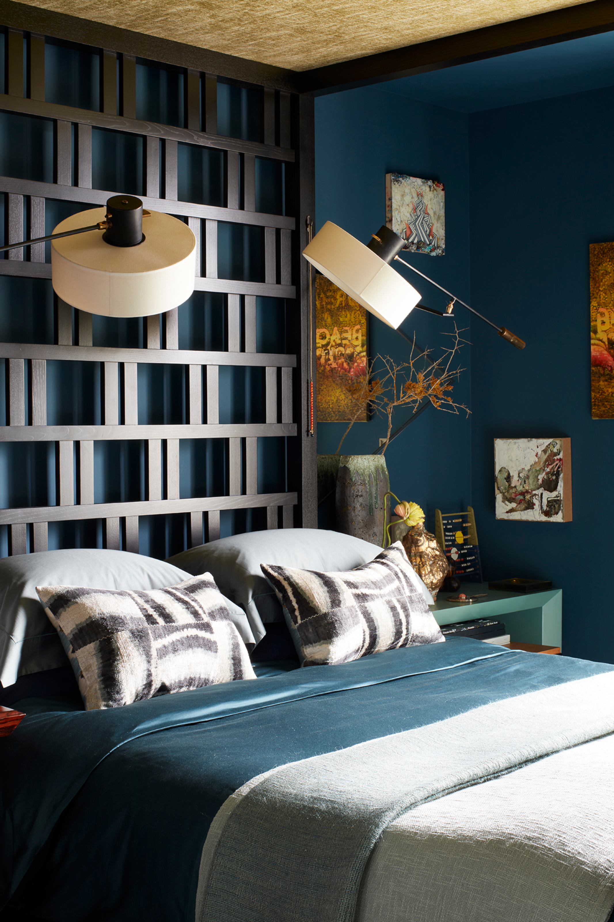 Blue bedroom with extended screen-like geometric headboard