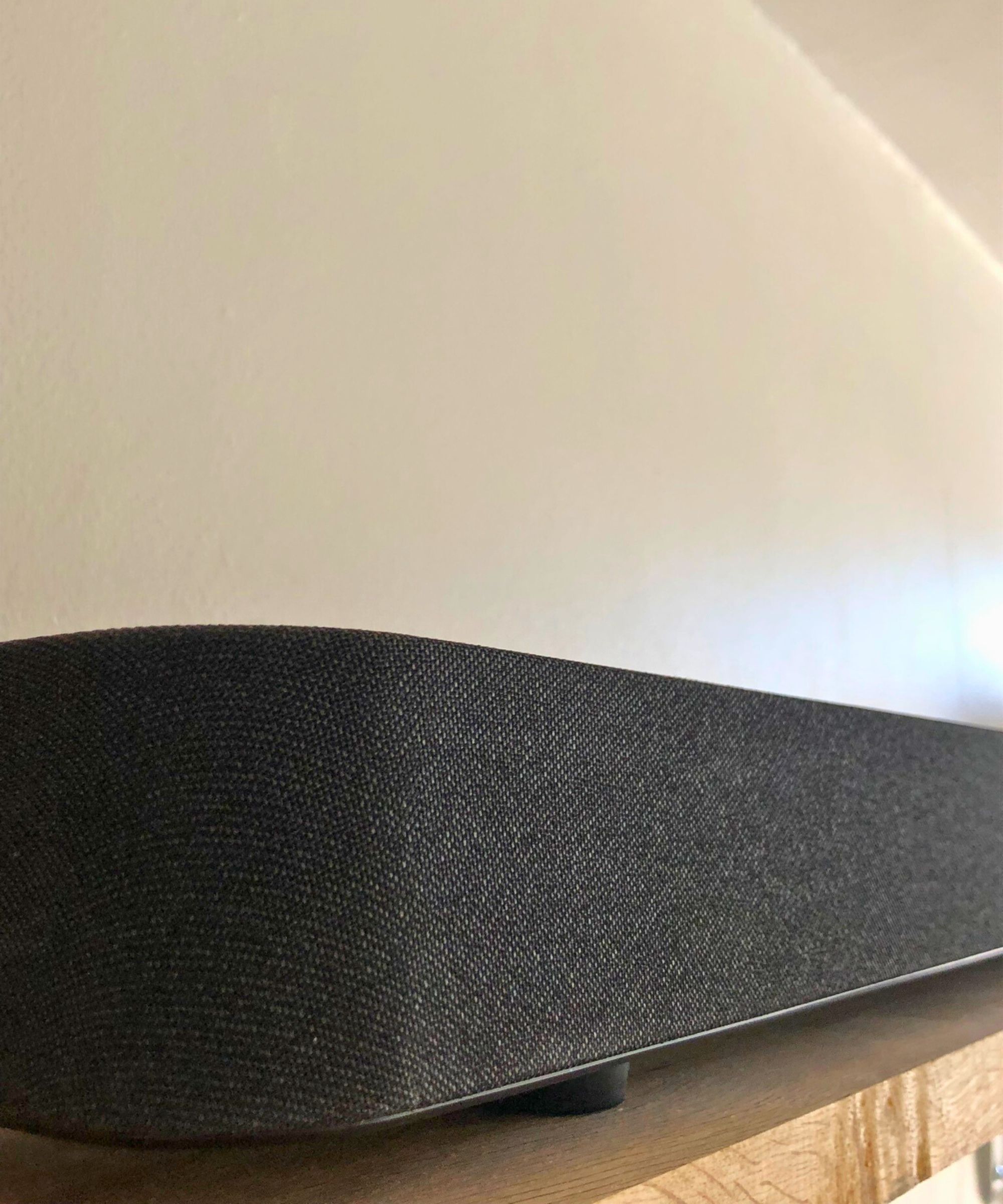 Closeup of the Sony BRAVIA Theater Bar 8 soundbar on wooden shelf against white wall in Dan Fauzi&#039;s home.