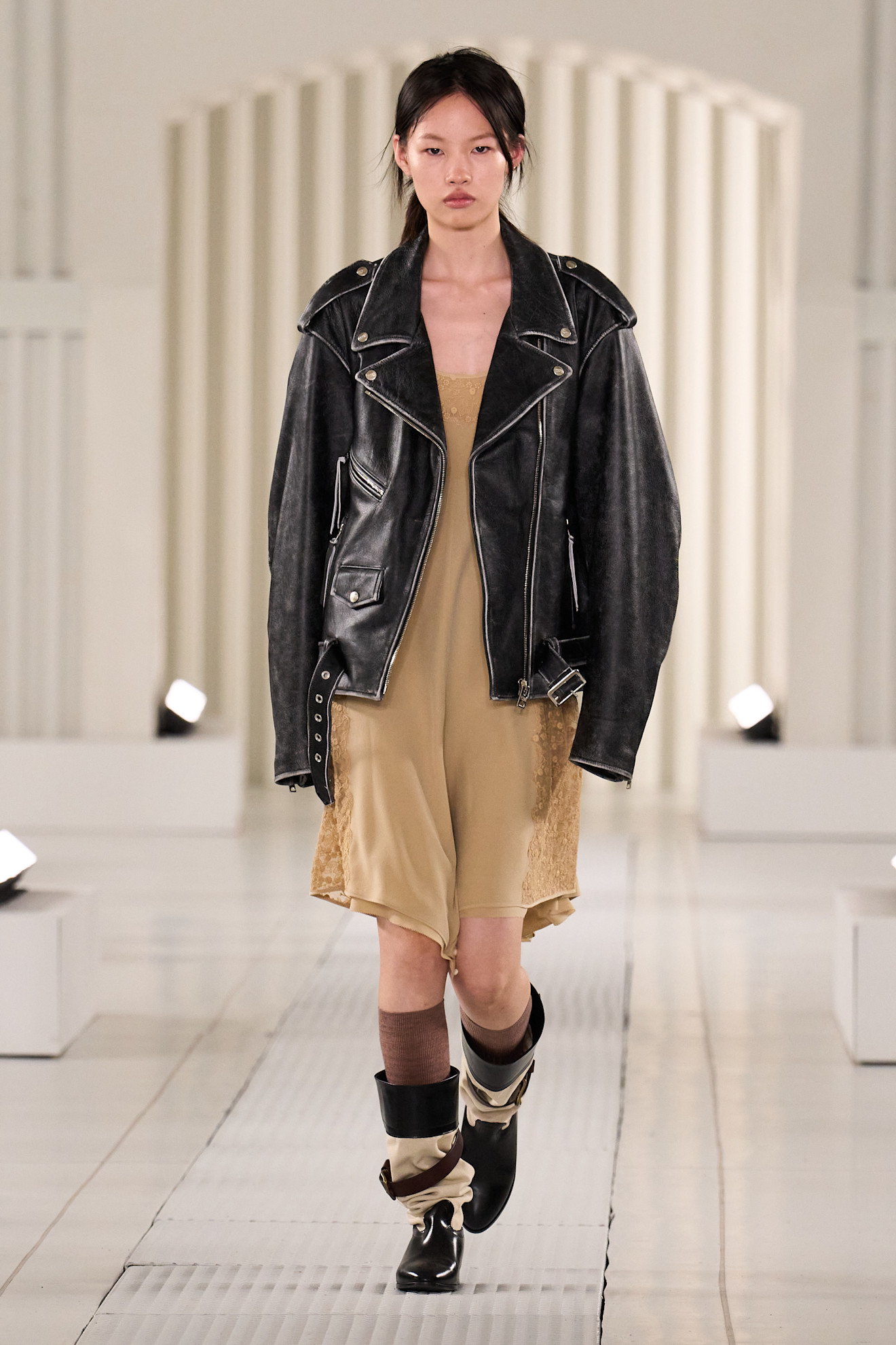 An image of the Onitsuka Tiger spring/summer 2026 runway featuring black ankle boots.
