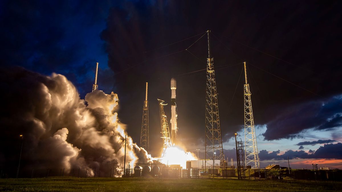 rocket launching during sunset with blue clouds in behind launch pad