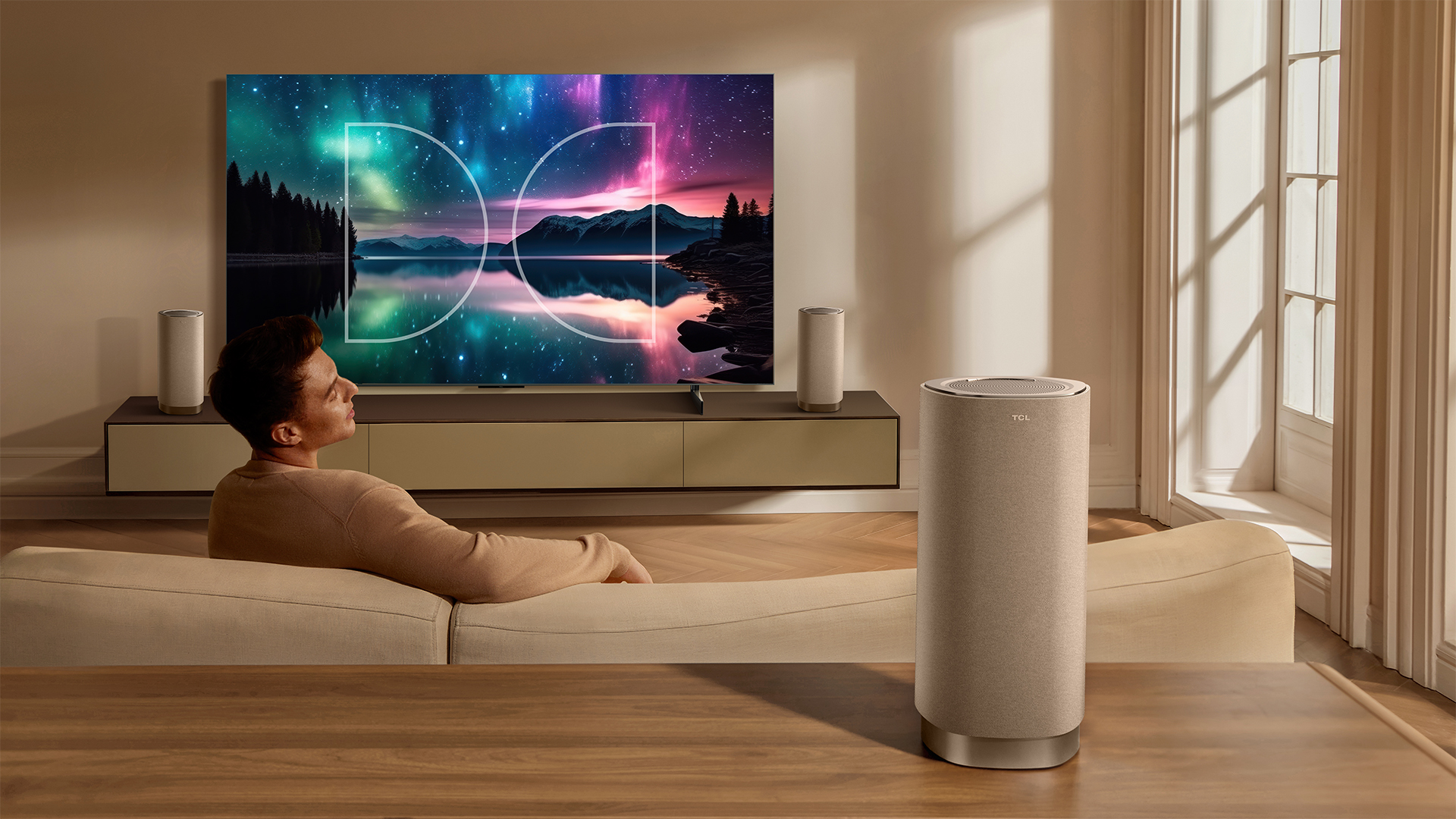 The TCL Z100 speaker behind a man watching TV