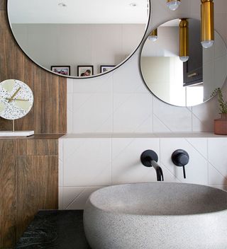 tiled bathroom vanity with stone sink and black tap