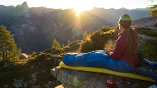 A woman doing a spot of bivvying and waking up to the sunrise