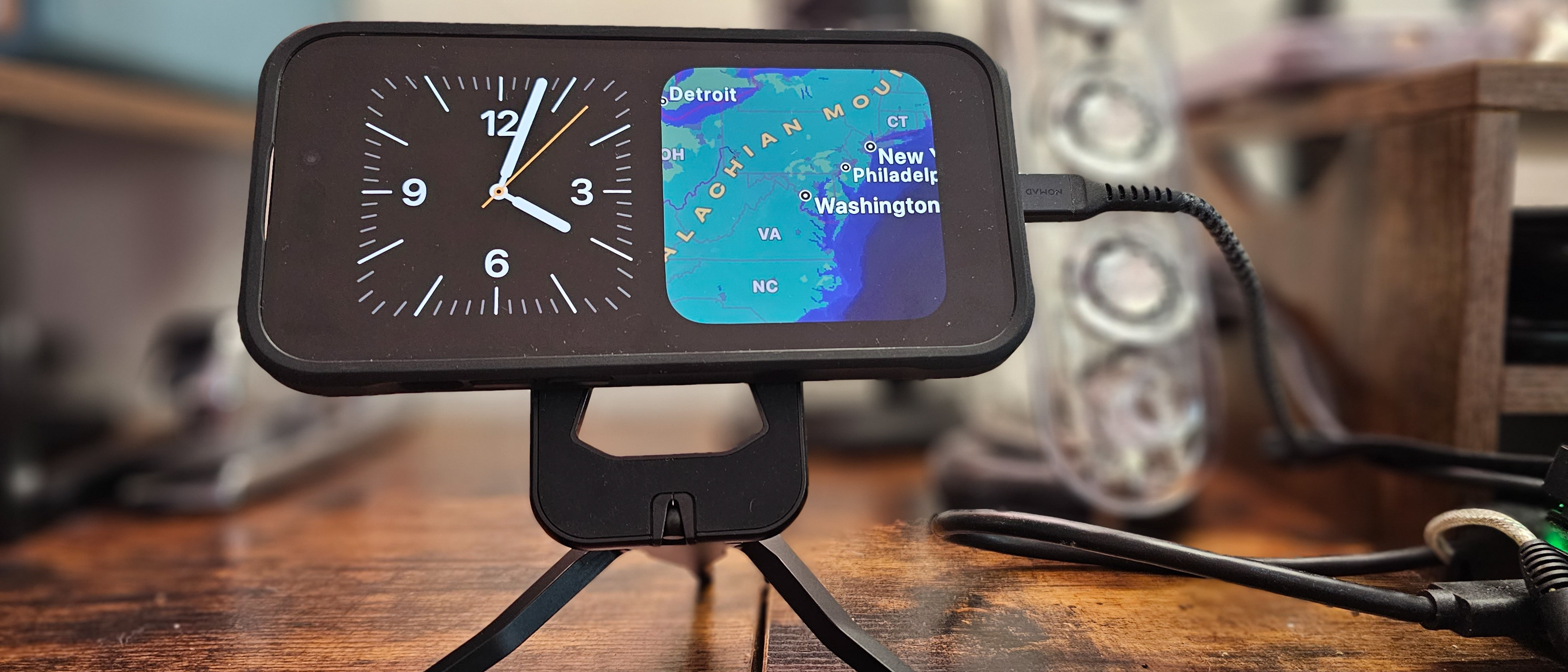 iOS 17 StandBy sur un iPhone 14 Pro affichant l'horloge et la carte météo
