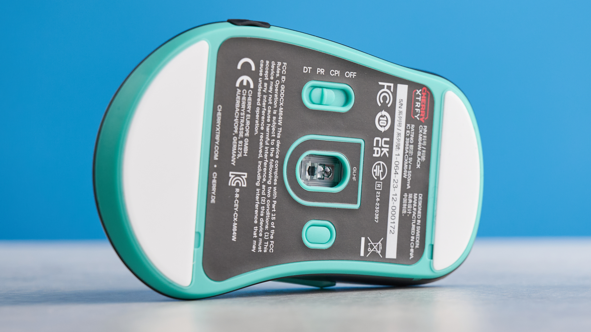 A black and teal Cherry XTRFY M64 Wireless gaming mouse