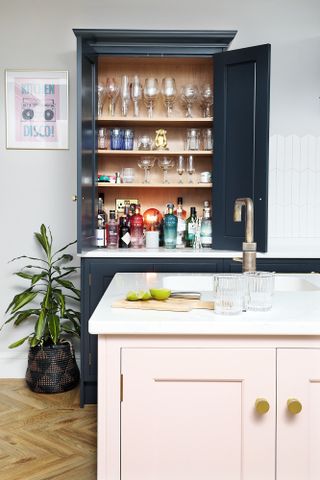 Bar cabinet contained within a dark blue Shaker-style kitchen unit