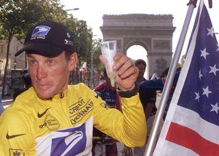 The winner of the 1999 Tour de France American Lance Armstrong drinks a cup of champagne during his honour lap on the Champs Elysees in Paris, 25 July 1999. (ELECTRONIC IMAGE) (Photo by JoÃ«l SAGET / AFP)