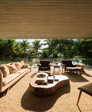 concrete modern house's living room with open side looking towards jungle