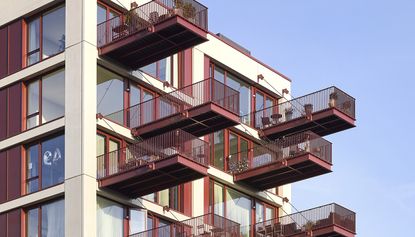 The Brentford Project neighbourhood showing green space against brick building with long balconies