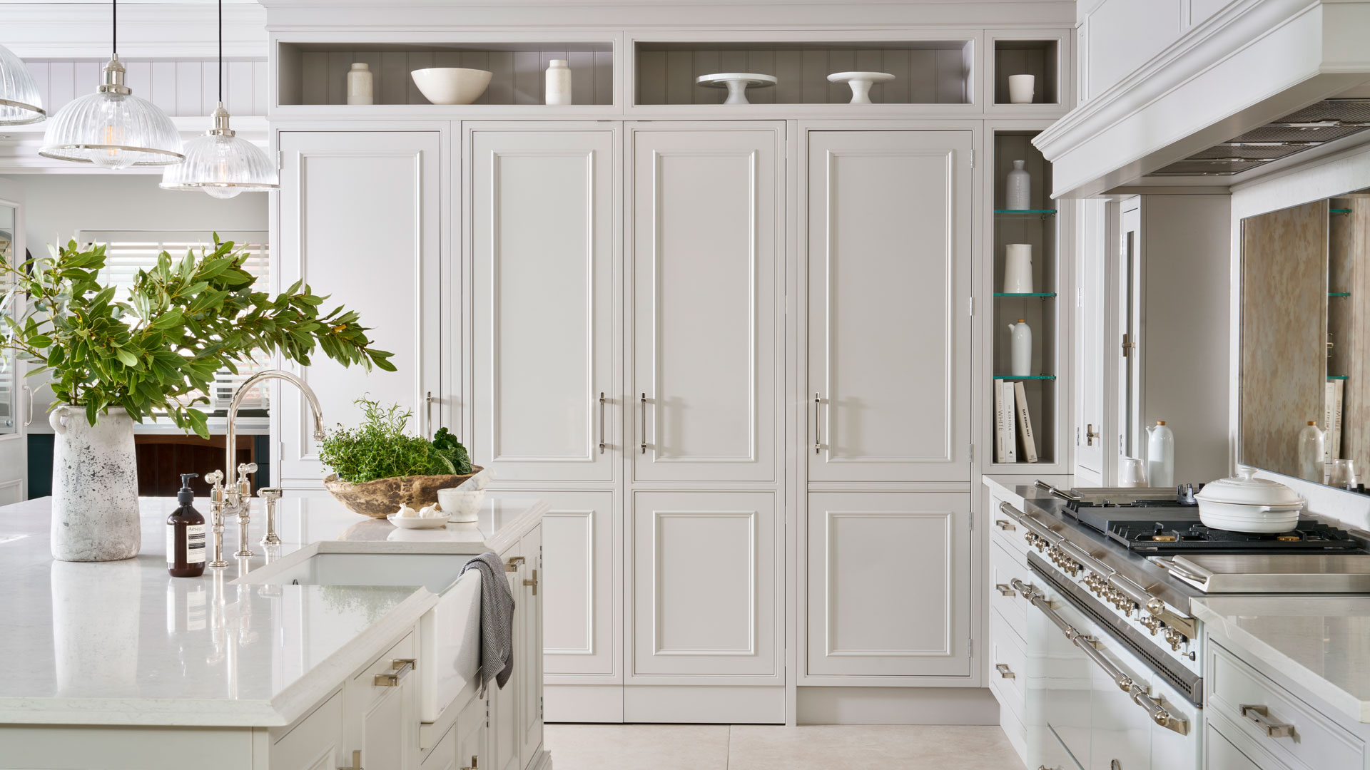 white kitchen with white range cooker and brass cabinet hardware