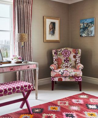 A bedroom corner with a colourful patterned armchair and rug