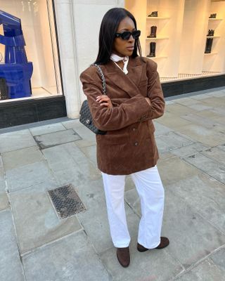 woman in white jeans and suede jacket