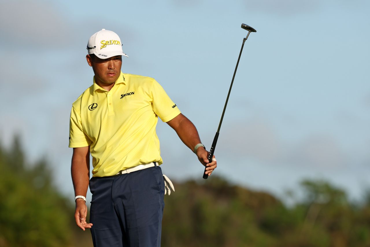 Hideki Matsuyama raises his putter in the air