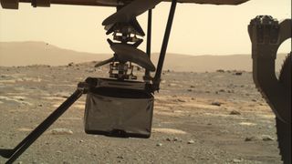 NASA's Mars helicopter Ingenuity is seen half unfolded beneath the Perseverance rover during deployment operations on March 29, 2021. It is the first helicopter on Mars.