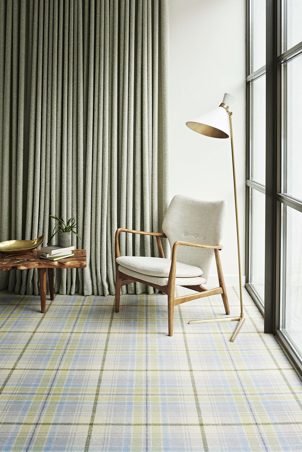 living room apartment with check carpet, pale green drapes, chair, wooden coffee table, white modern floor lamp