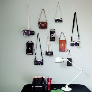 wall with retro cameras and desk with lamp