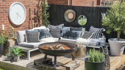 an outdoor seating area with outdoor wall decor ideas including a clock and mirrors