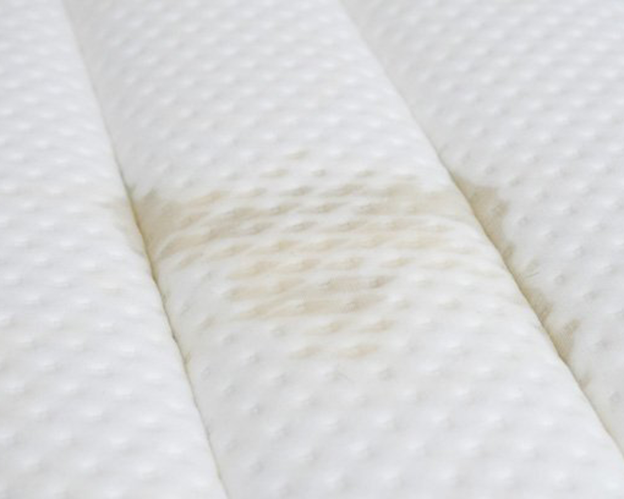 A white mattress with light brown stain