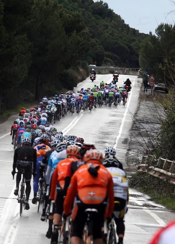 The peloton streams into the cold, wet distance.