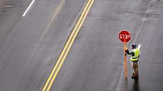 A construction worker holds a stop sign